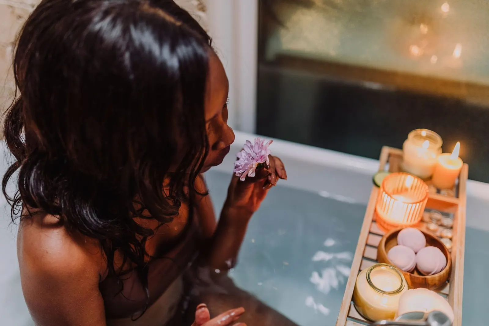 Woman relaxing in a bath with candles